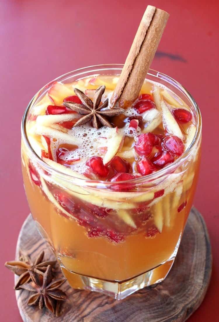 Sparkling Apple Cider Sangria is our favorite fall sangria recipe! Crisp apple cider with a cinnamon kick from Fireball, topped with prosecco! glass of sparkling fireball sangria with a cinnamon stick