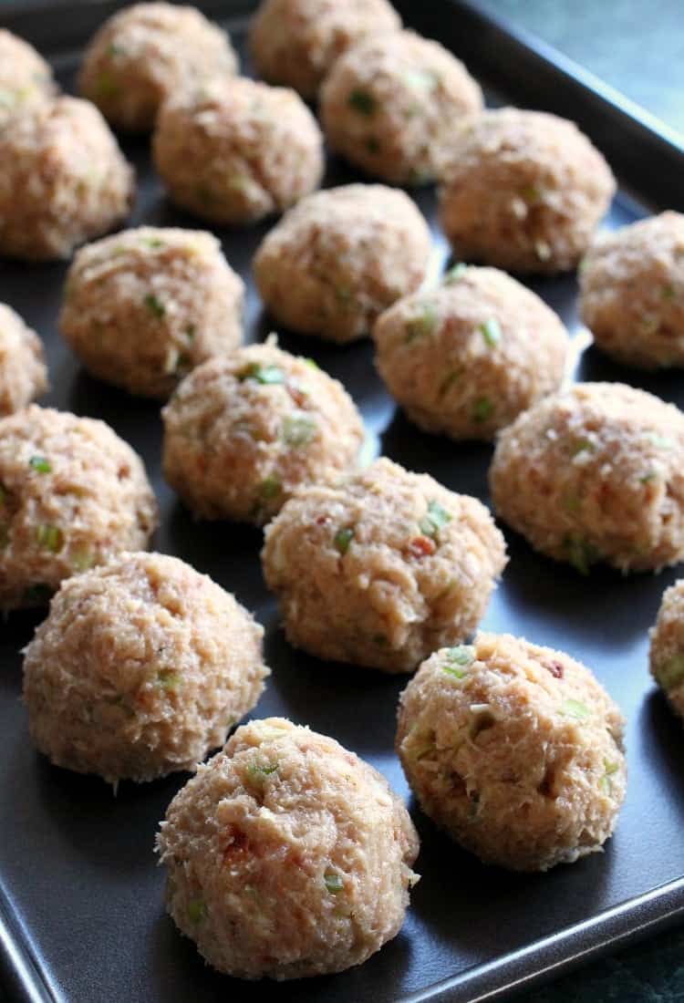 Cheese Doodle Chicken Meatballs are the ultimate party food! Chicken meatballs, stuffed with cheese and bacon with a crunchy cheesy crust! Cheese Doodle Chicken Meatballs on baking sheet