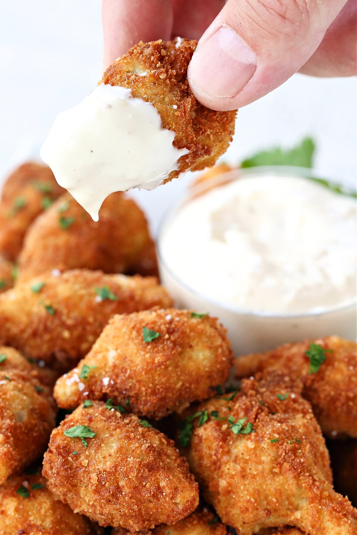 These Fried artichoke hearts are a crispy and addicting appetizer! Make our easy roasted garlic aioli to serve alongside for dipping! fried artichoke dipped into garlic aioli