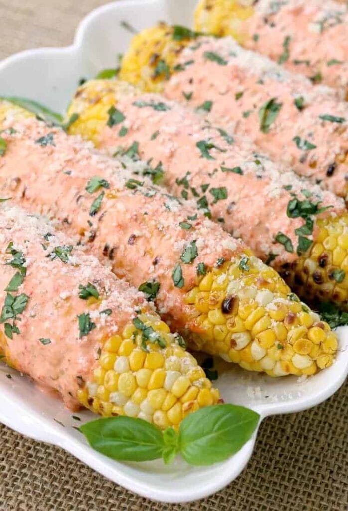 Grilled Italian Street Corn covered with red pepper mayo and cheese!