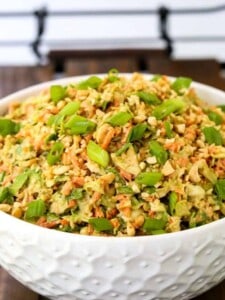 Thai Peanut Brussels Sprout Coleslaw in a white bowl on a serving tray