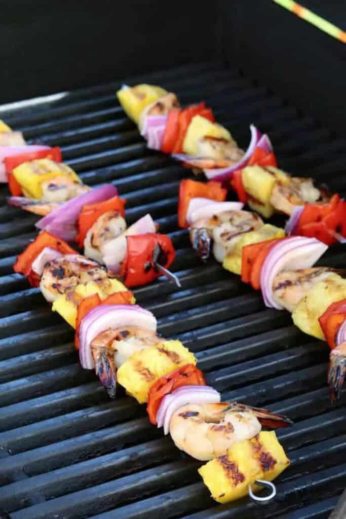 Piña Colada Shrimp Kabobs are the ultimate summer dinner! Juicy shrimp with a real piña colada flavor grilled with pineapple and vegetables. shrimp kabobs on a grill
