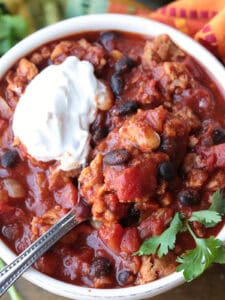 chili in a bowl with sour cream and spoon
