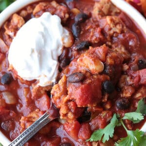 chili in a bowl with sour cream and spoon