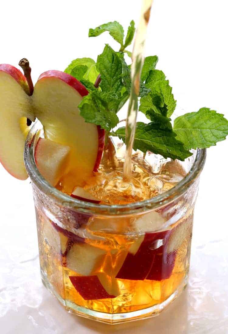 A refreshing Apple Whiskey Iced Tea is perfect for warm Fall days. A classic whiskey iced tea kicked up with apple liquor and fresh apples. This Apple Mint Whiskey Iced Tea is the perfect Fall cocktail!