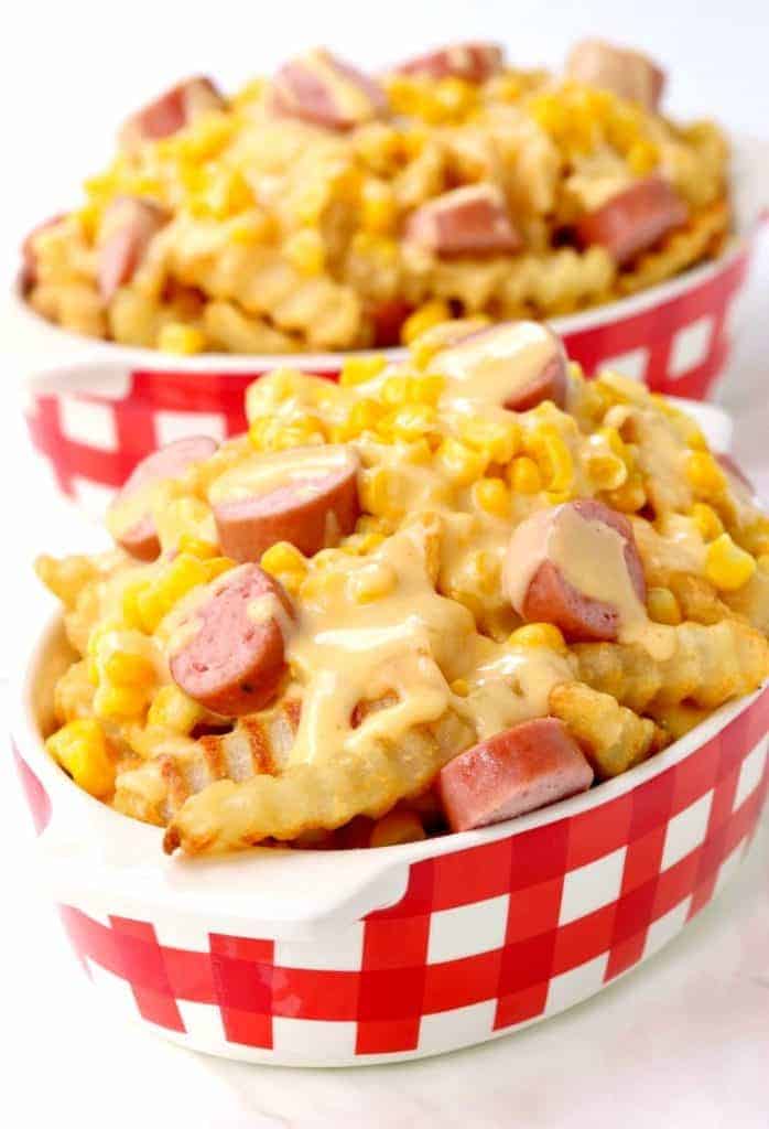 This Corn Dog Poutine is topped with cheese sauce, corn and hot dogs!