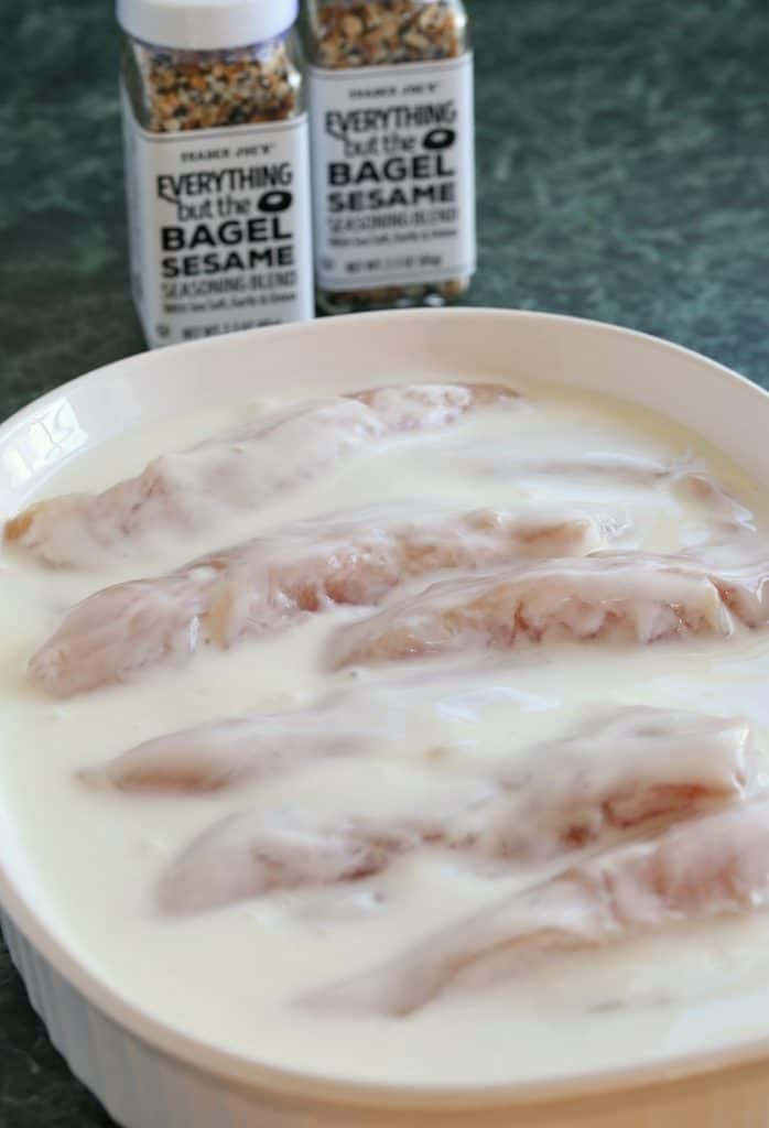 Chicken Tenders soaking in buttermilk for a chicken finger recipe