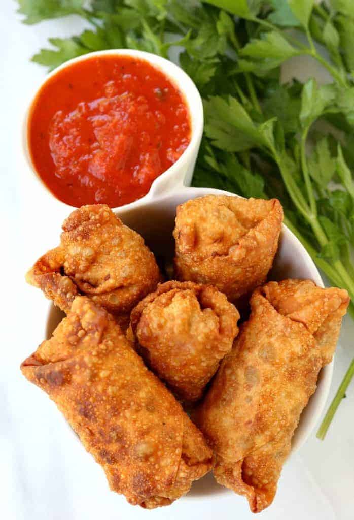 Italian Egg Rolls in a bowl with marinara dipping sauce