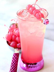 A pink shirley temple drink in a tall glass