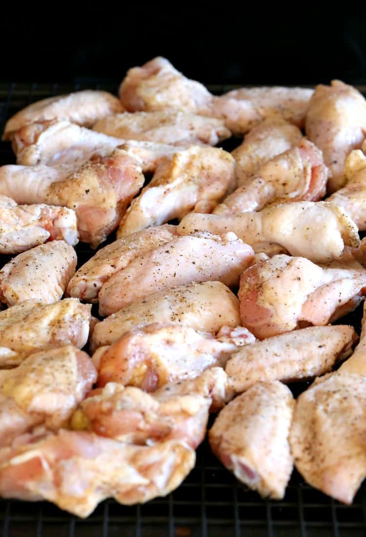 Raw bone-in chicken wings with salt and pepper seasoning.