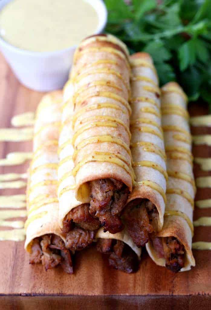 These Honey Mustard Pulled Pork Taquitos are baked and drizzled with a creamy honey mustard sauce!