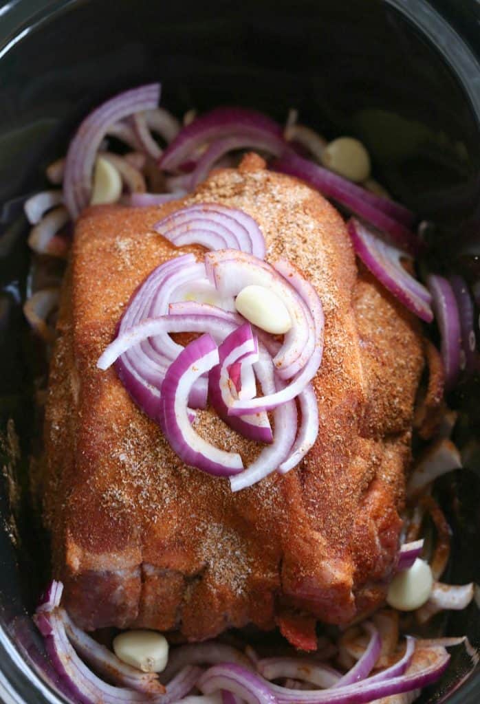 seasoned pork butt with onions in slow cooker