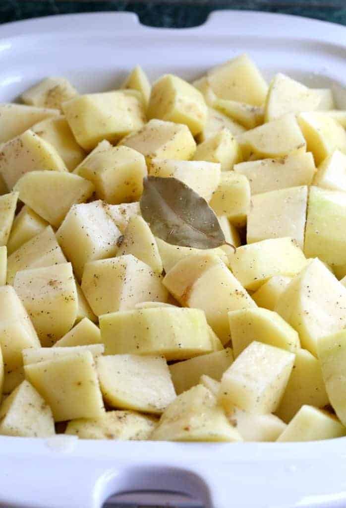 Diced potatoes in a slow cooker used to make slow cooker mashed potatoes