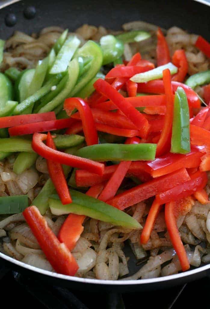 German Style Sausage and Peppers start by cooking peppers and onions in a skillet