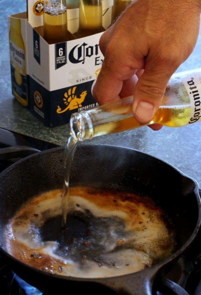 Pouring beer into a skillet to make a beer queso recipe