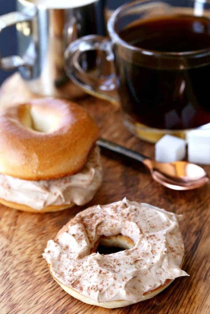 Spreading coffee flavored cream cheese on a bagel