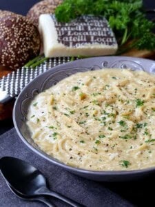 Cacio e Pepe Chowder in a bowl with bread and cheese