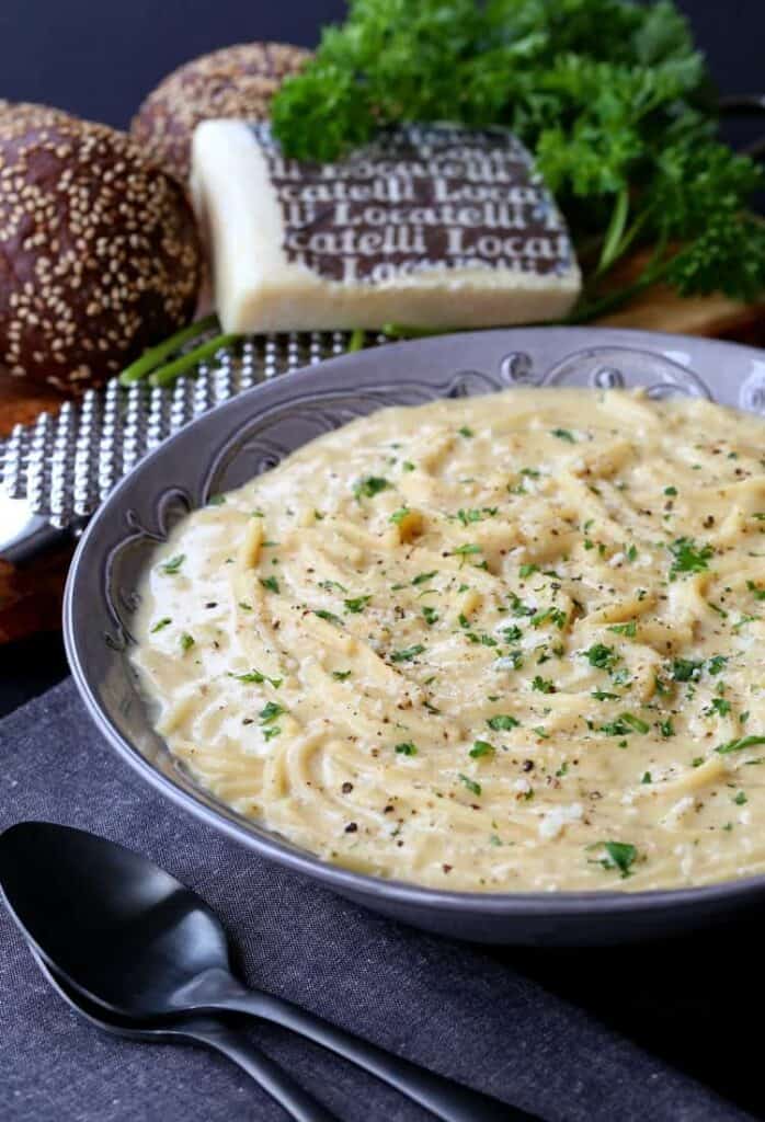 Cacio e Pepe Chowder in a bowl with bread and cheese