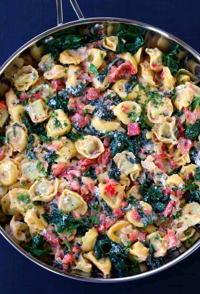 tortellini with spinach and tomatoes in skillet