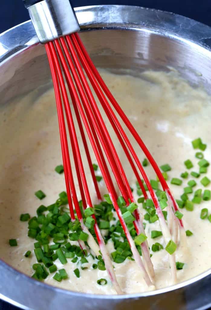 A red whisk stirring up dipping sauce ingredients 