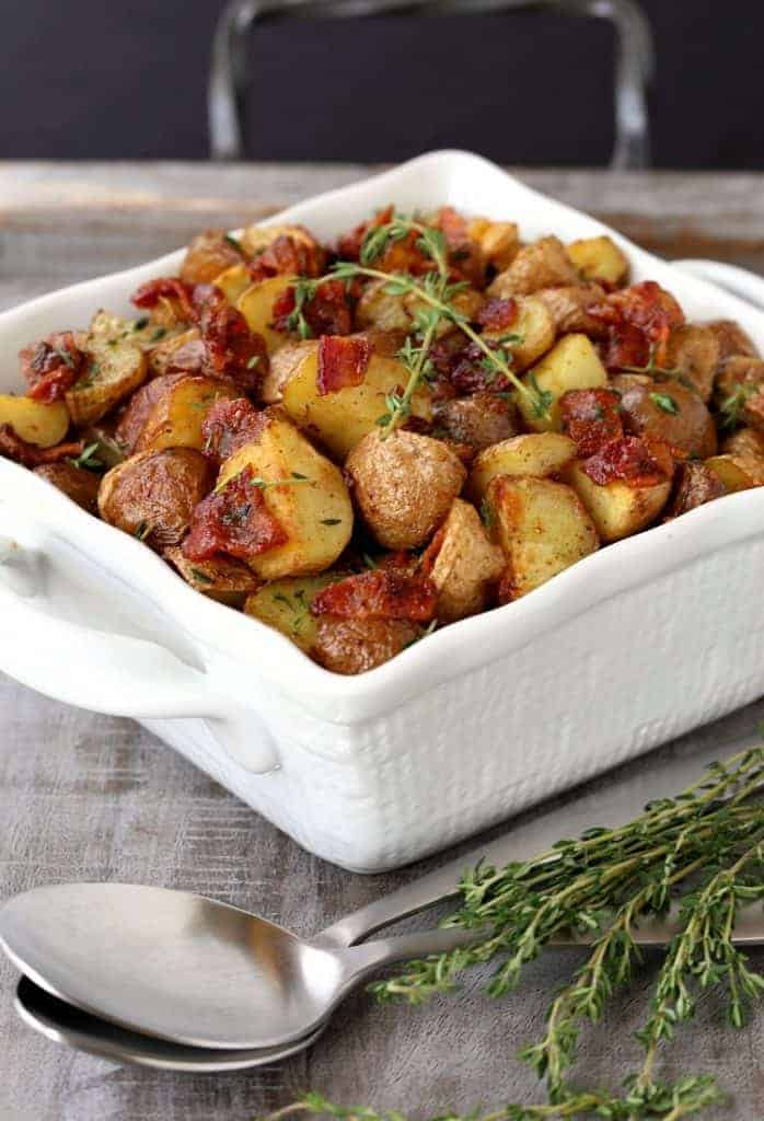 Crispy Oven Roasted Bacon Potatoes in a white bowl on a board