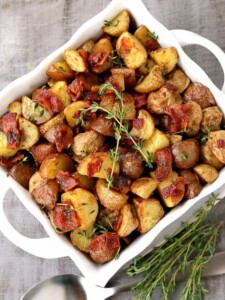 Crispy Oven Roasted Bacon Potatoes in a white bowl from the top view with spoons