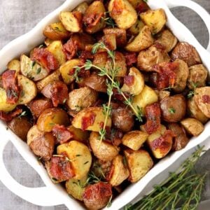 Crispy Oven Roasted Bacon Potatoes in a white bowl from the top view with spoons