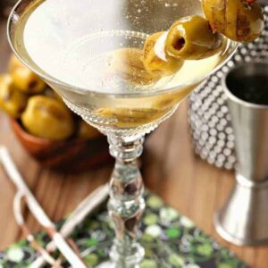 Grilled Dirty Martini in glass with shaker and olives