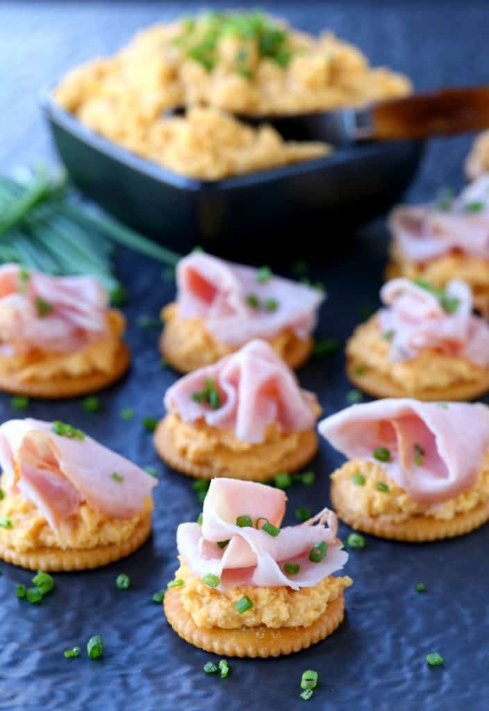 Ham and Pub Cheese Crackers on a cheese board with bowl of cheese