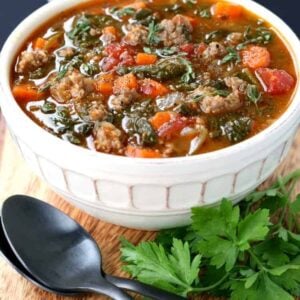 Low Carb Sausage Vegetable Soup in a bowl on a board with spoons