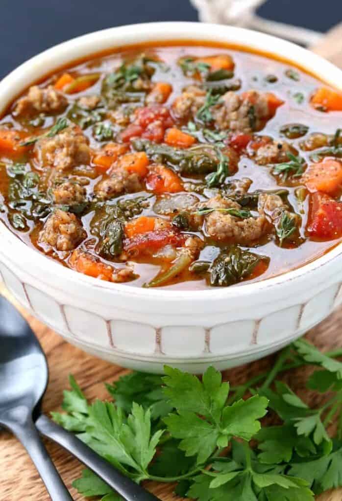 Low Carb Sausage Vegetable Soup on a board with parsley