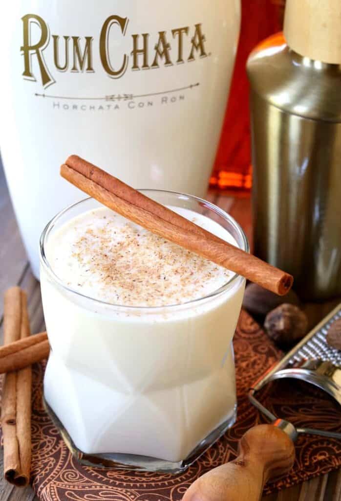 Campfire Milk Punch in a glass with a bottle of RumChata