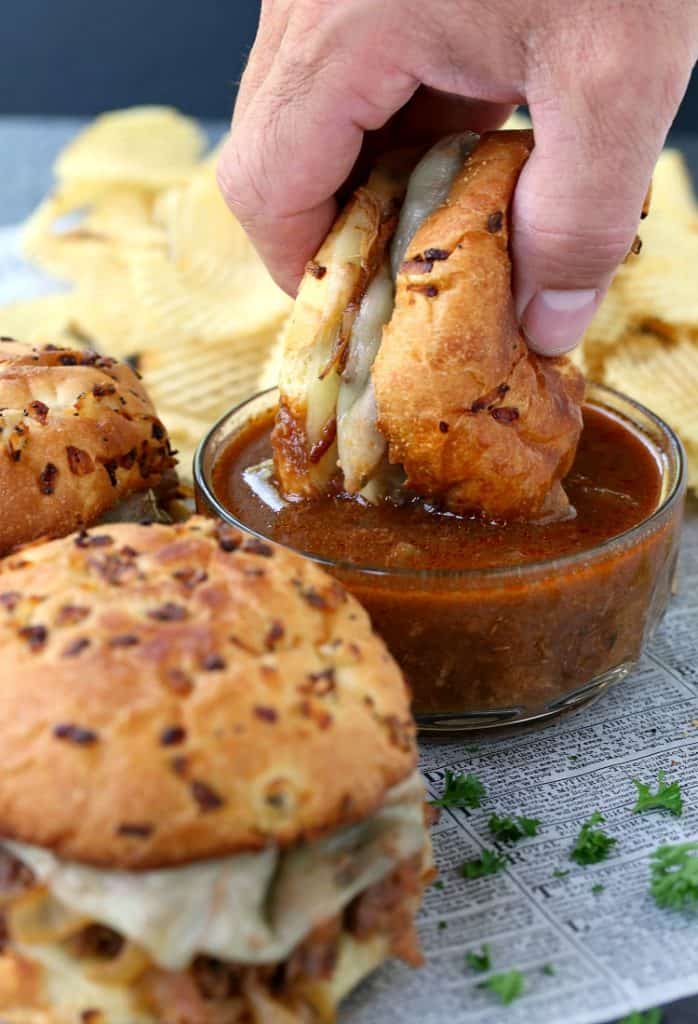 Slow Cooker BBQ French Dip Sandwiches dipped into sauce