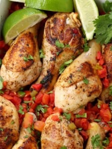 Oven Baked Fiesta Chicken Legs in a dish with limes