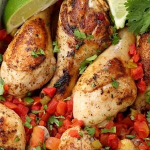 Oven Baked Fiesta Chicken Legs in a dish with limes