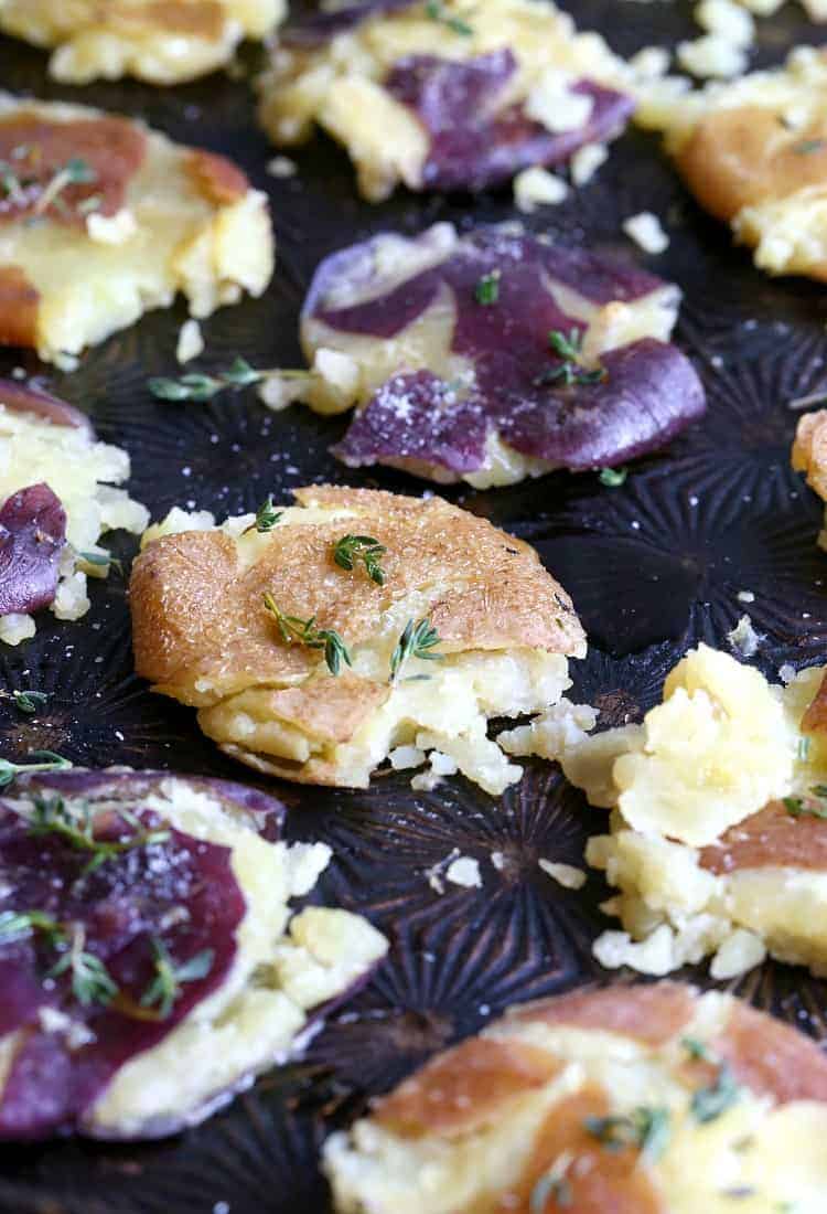 smashed potatoes with thyme on a sheet pan