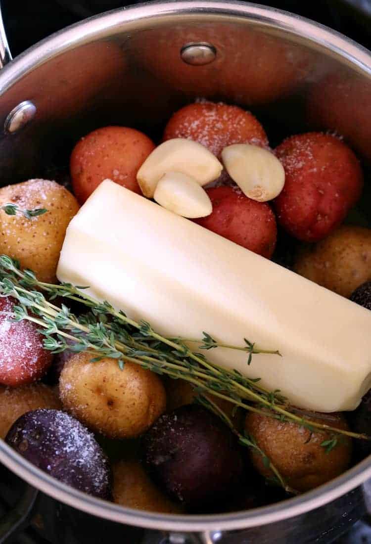 stick of butter in a pot with potatoes