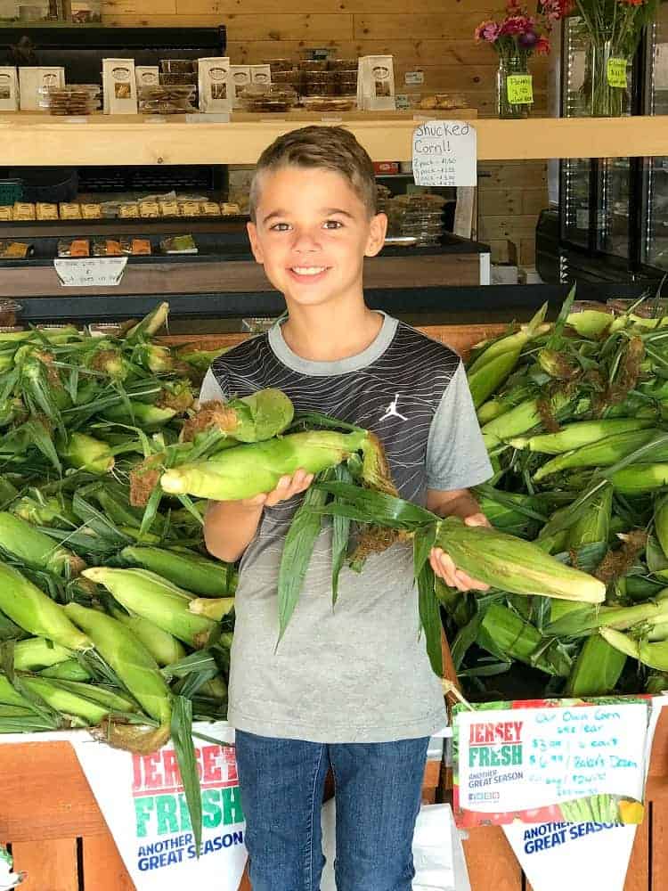 Evan at the farm stand with corn