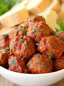 Grandma's Sunday Meatballs and Sauce close up in a white bowl with bread