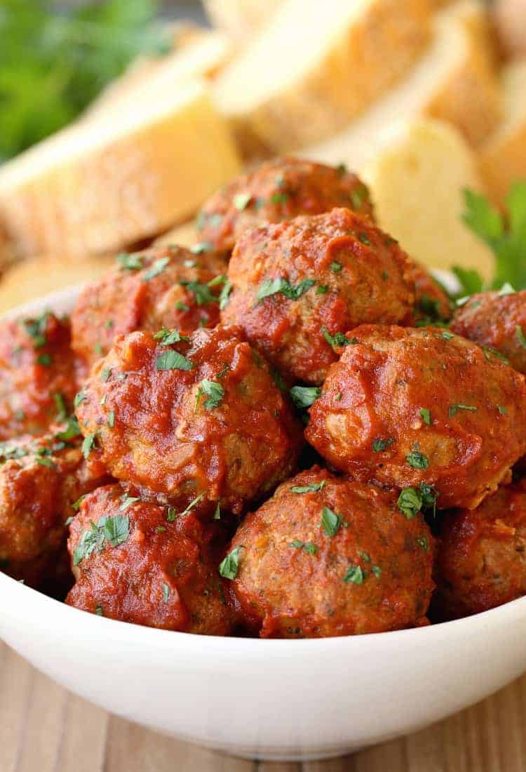 Grandma's Sunday Meatballs and Sauce close up in a white bowl with bread