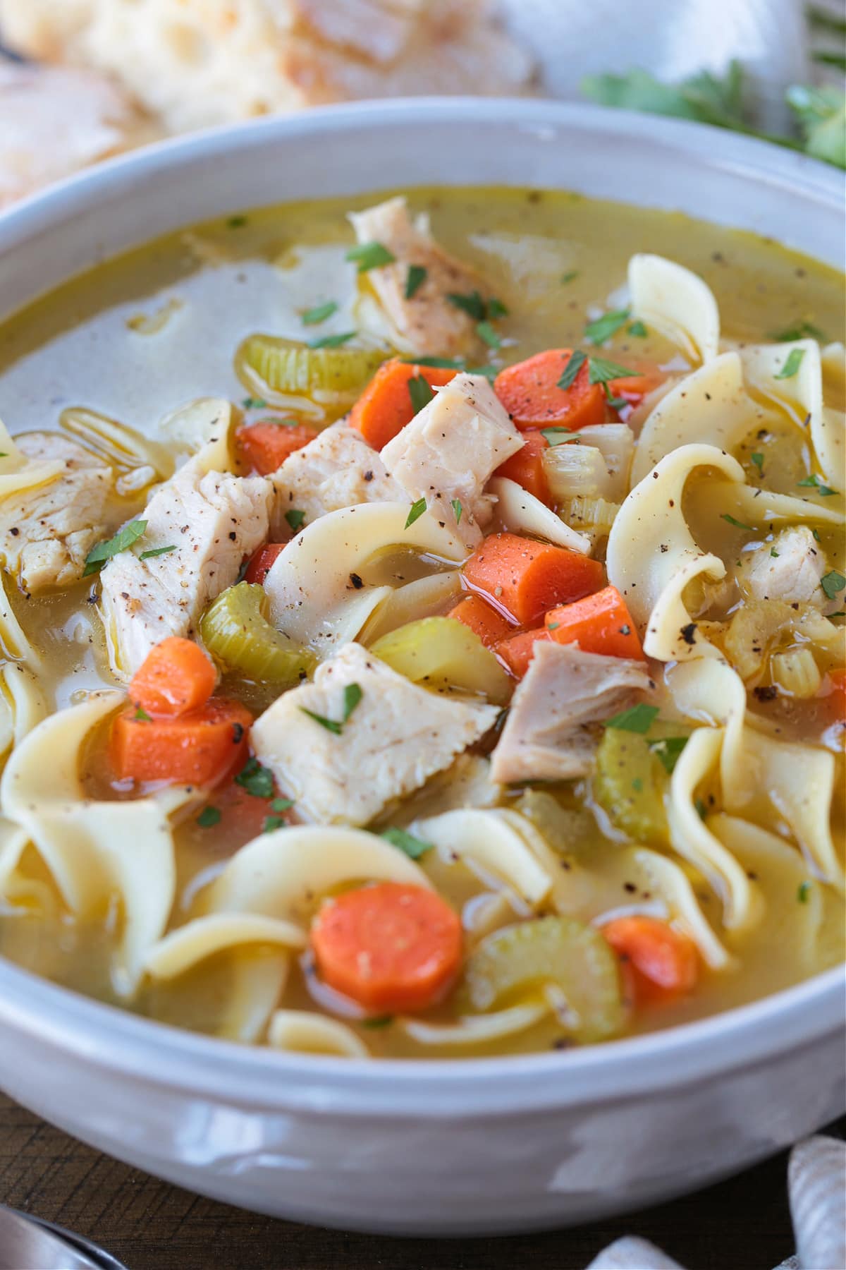 homemade turkey soup in a white bowl from the side