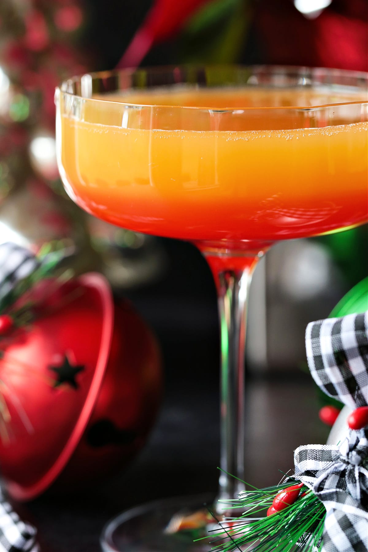 This Christmas Mimosa Recipe is perfect for your holiday parties and brunches! A beautiful, layered cocktail that tastes as good as it looks! mimosa recipe with grenadine and Christmas decorations in the background