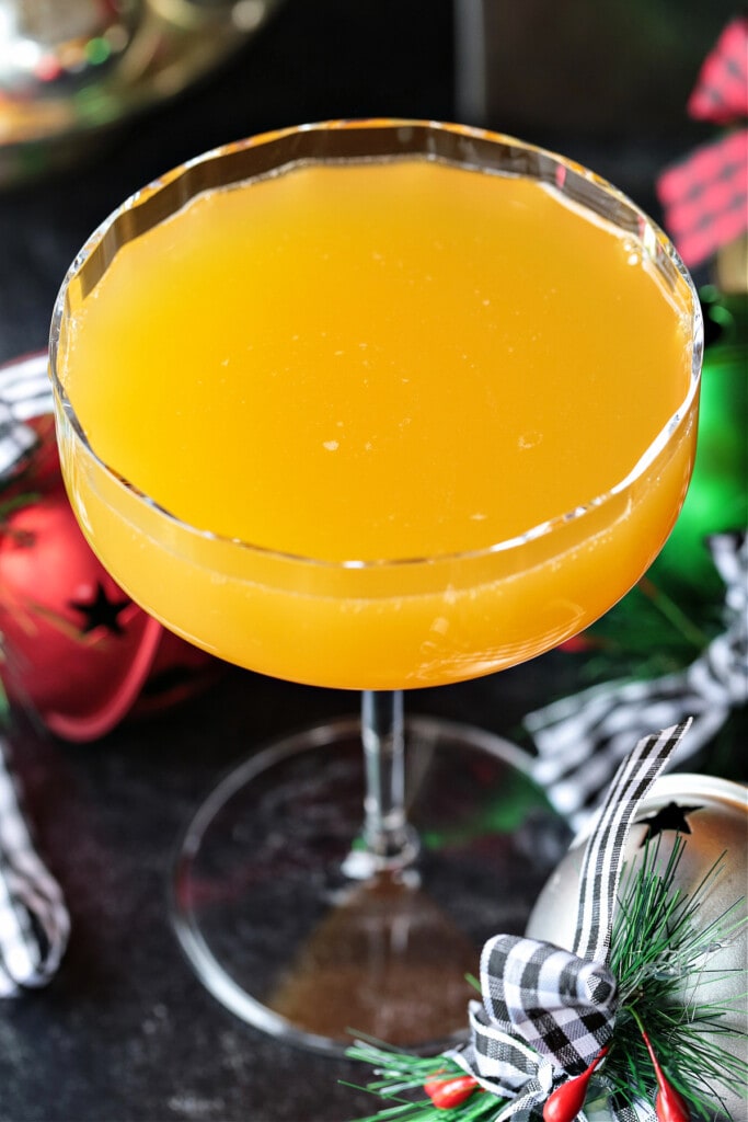 This Christmas Mimosa Recipe is perfect for your holiday parties and brunches! A beautiful, layered cocktail that tastes as good as it looks! orange juice on top of champagne for mimosa recipe