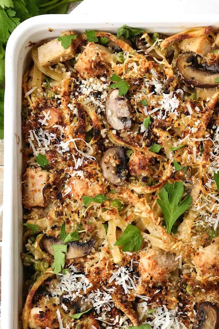 A pasta casserole recipe with peas and mushrooms in a baking dish