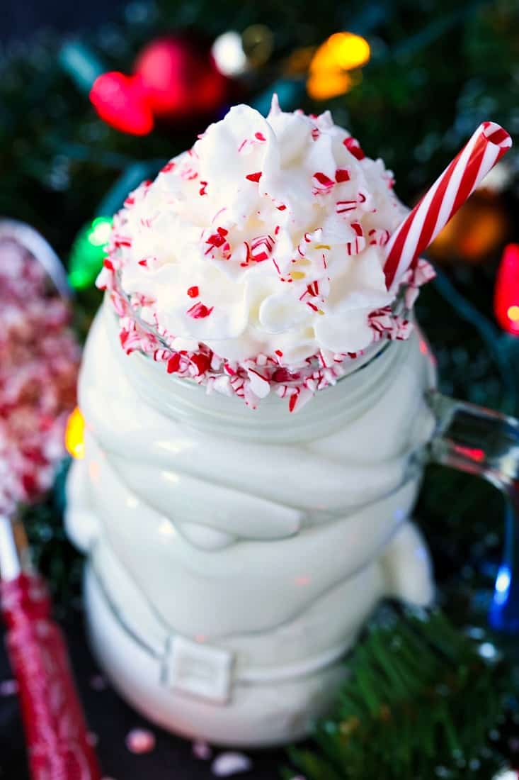 Spiked White Hot Chocolate in a santa mug with peppermint candies
