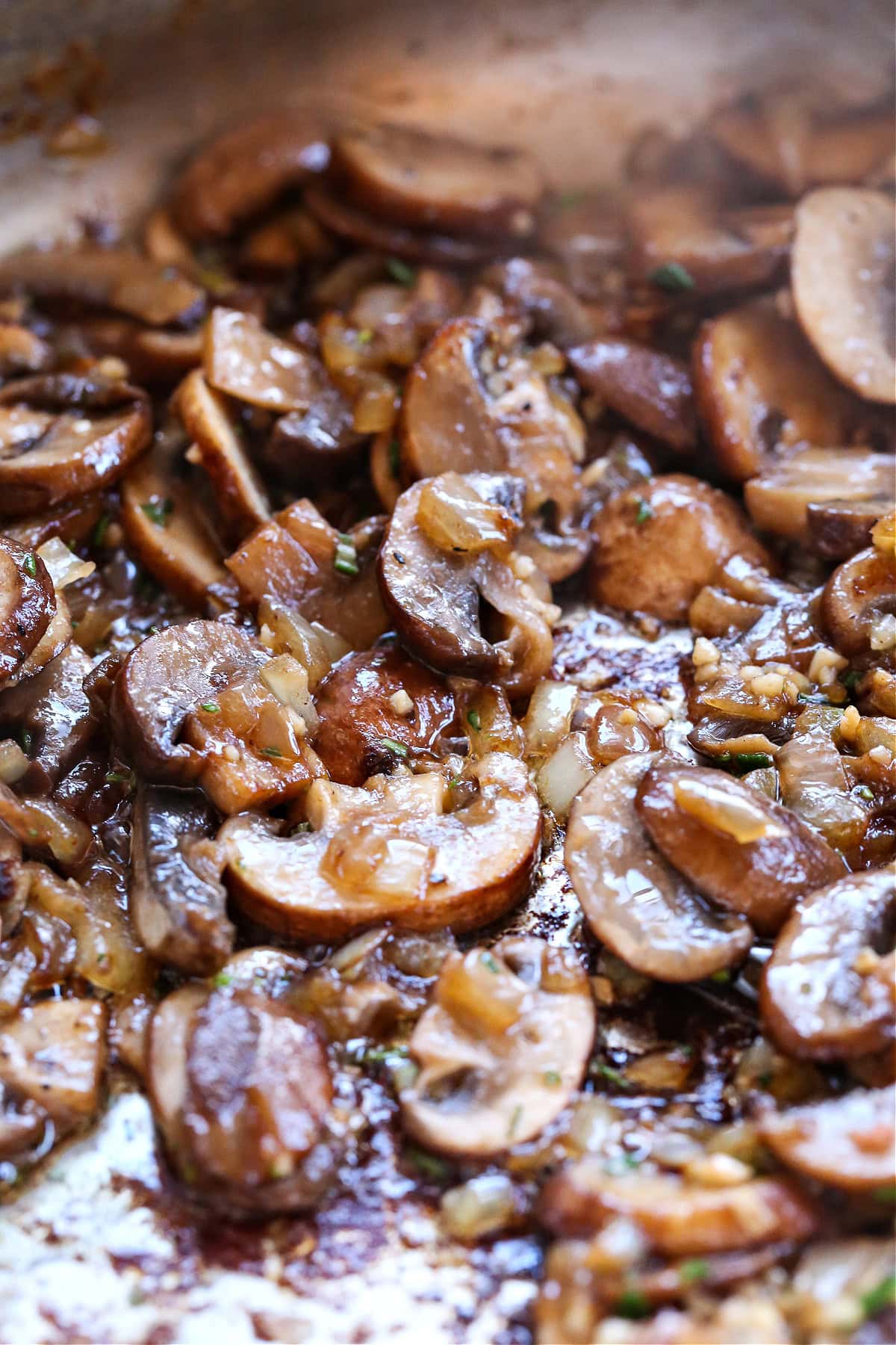 cooked, sliced mushrooms in a skillet with onions and garlic