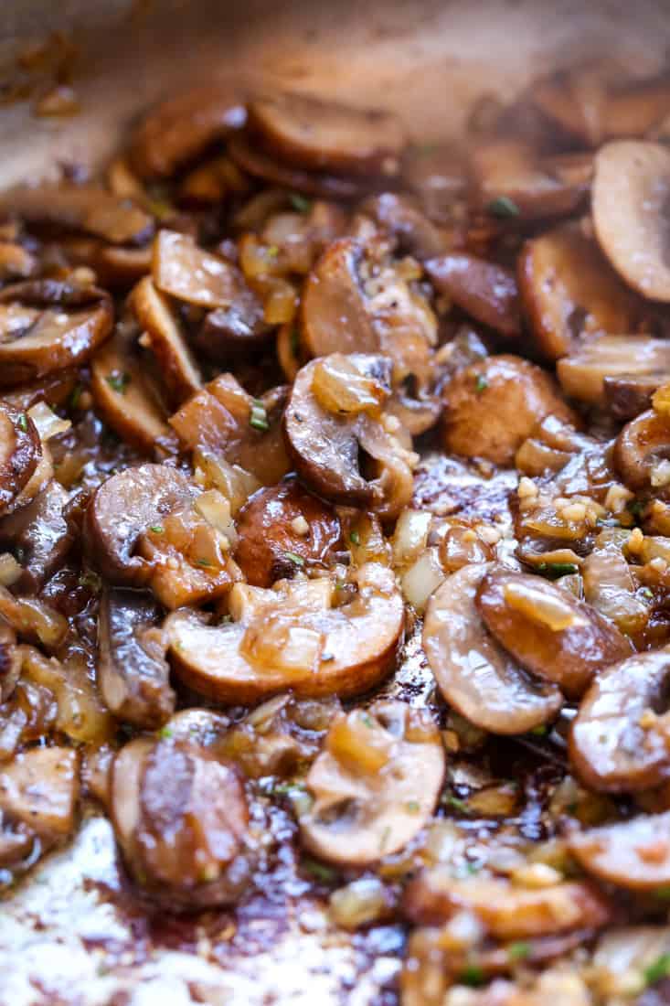 Mushrooms and onions being cooked in a pan