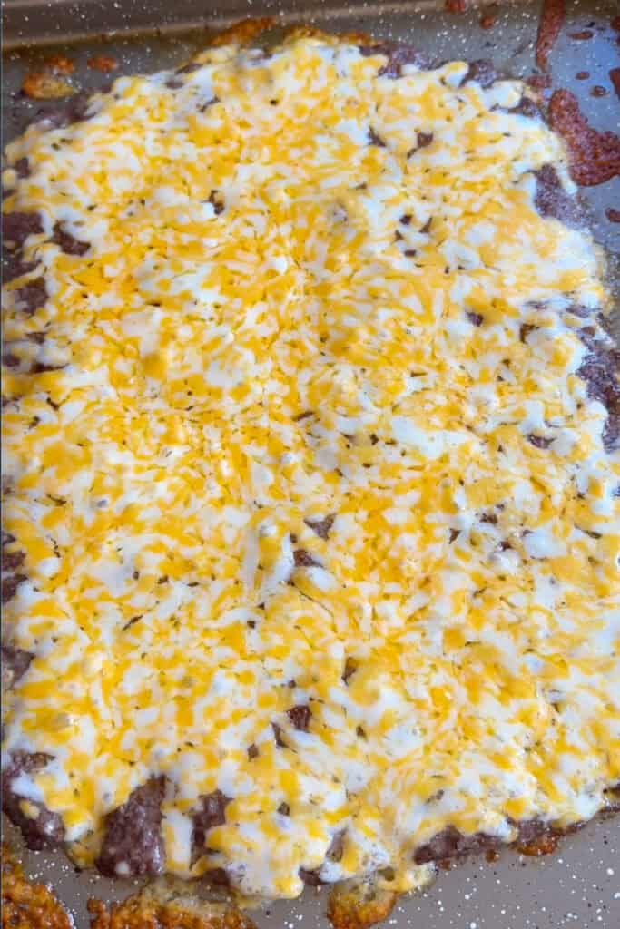Make these Naked Sheet Pan Tacos for your next taco night! A high protein dinner that everyone will love. Ready in less than 30 minutes! cheese melted on ground beef on a sheet pan