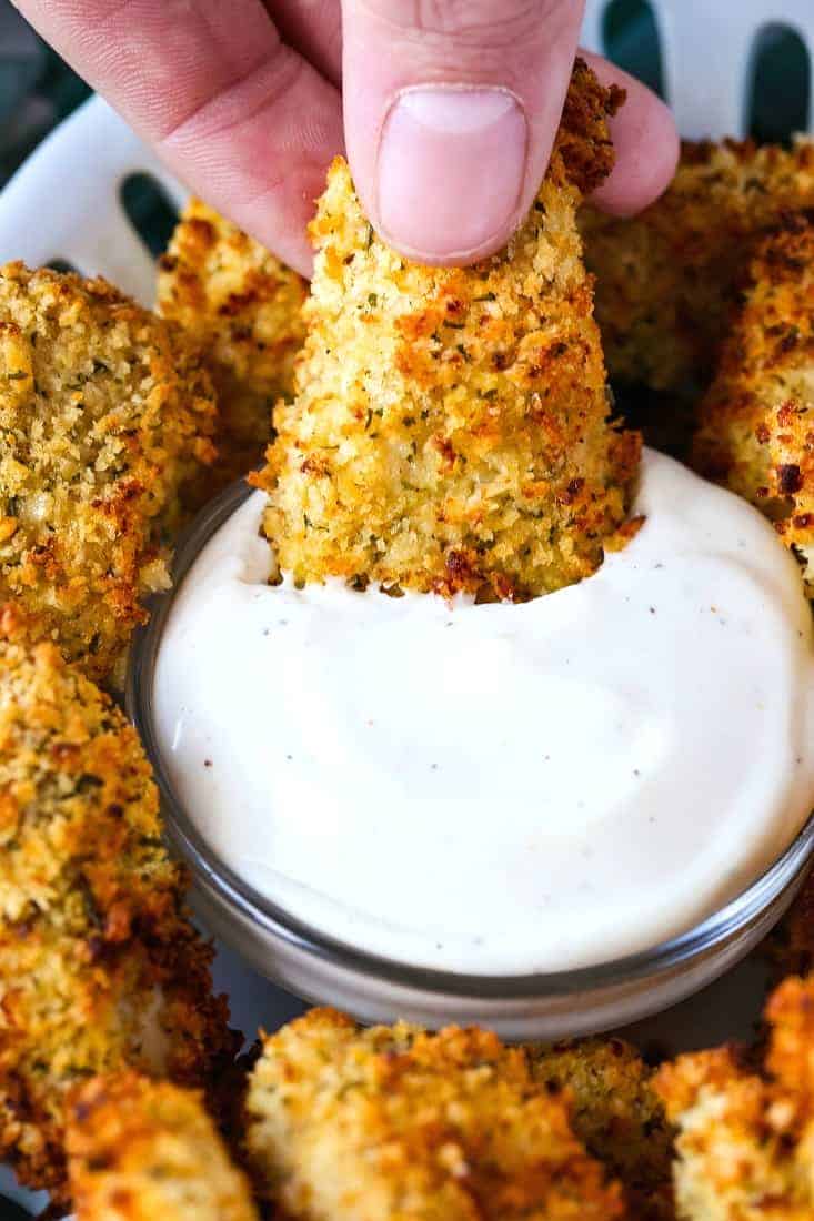 Chicken nuggets being dipped into ranch dressing