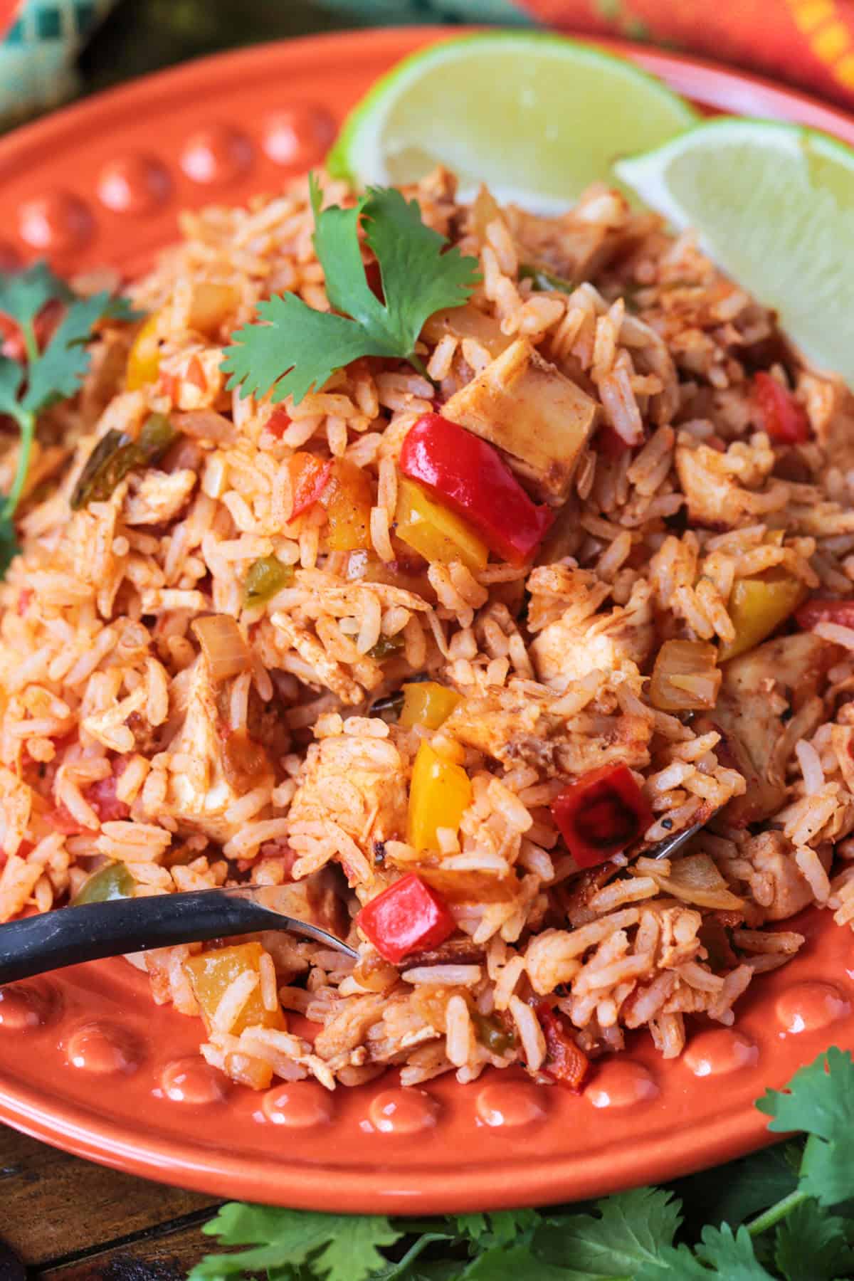 Chicken Fajita Rice is packed with charred vegetables, tender chicken and seasoned rice. Ideal for busy nights, ready in less than 30 minutes! chicken fried rice recipe with peppers and onions on plate with fork